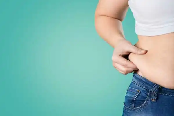 Image of woman pinching her love handles to show weight gain Blackpool